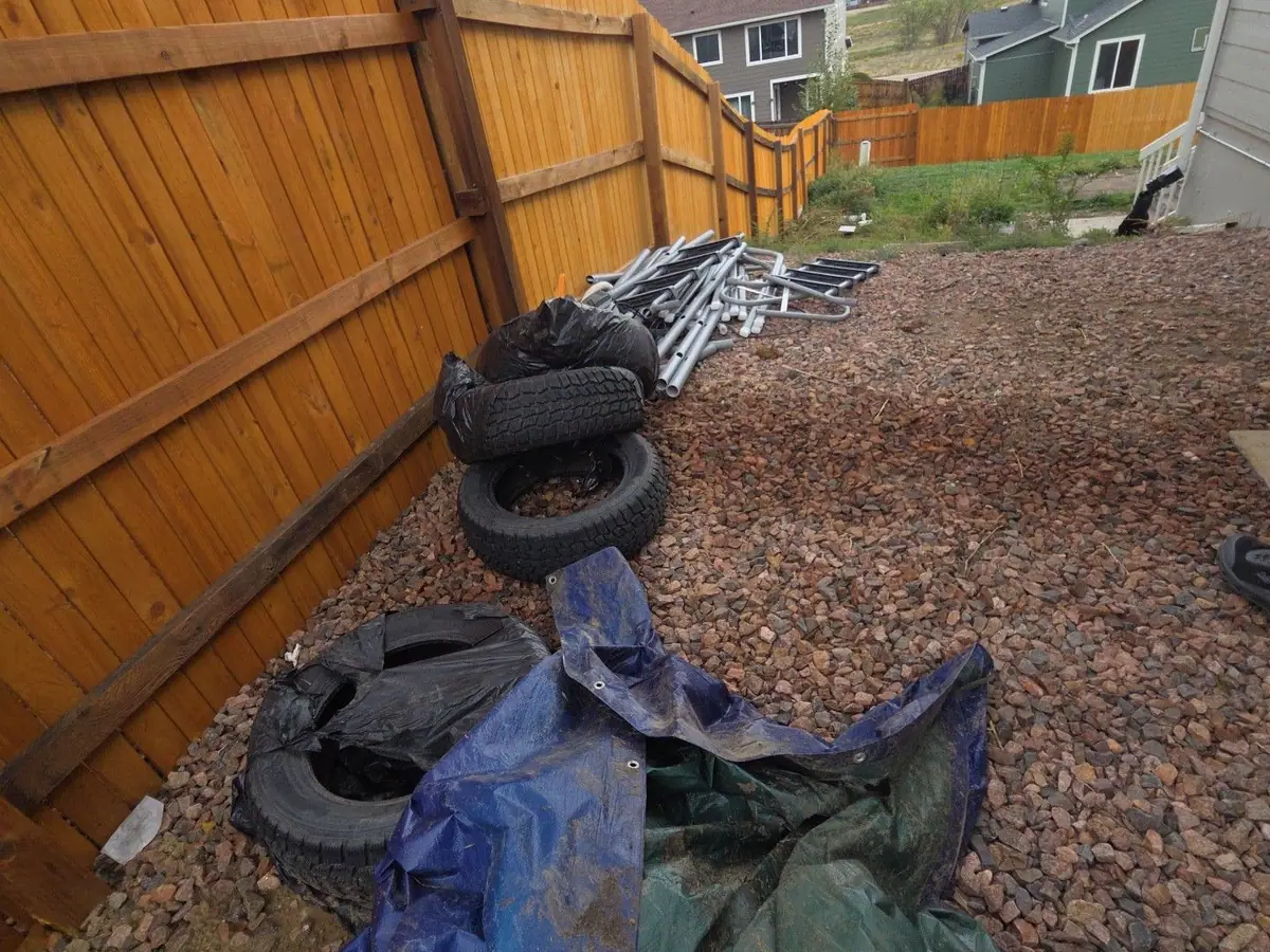 Old tires and tarps dumped along a fence line