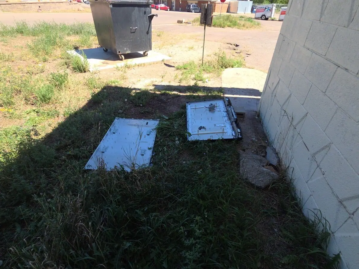Old panels dumped in the grass behind a business
