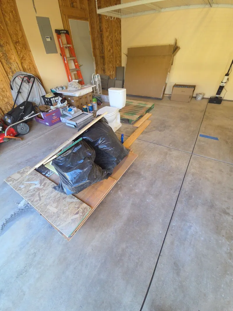 Drywall scraps bags and leftover materials in an empty commercial bay