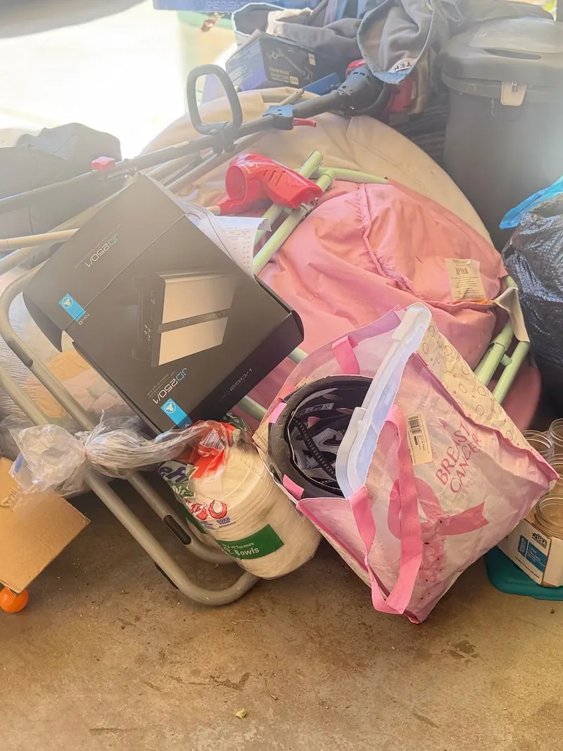 Bags and boxes and household junk piled on a garage floor