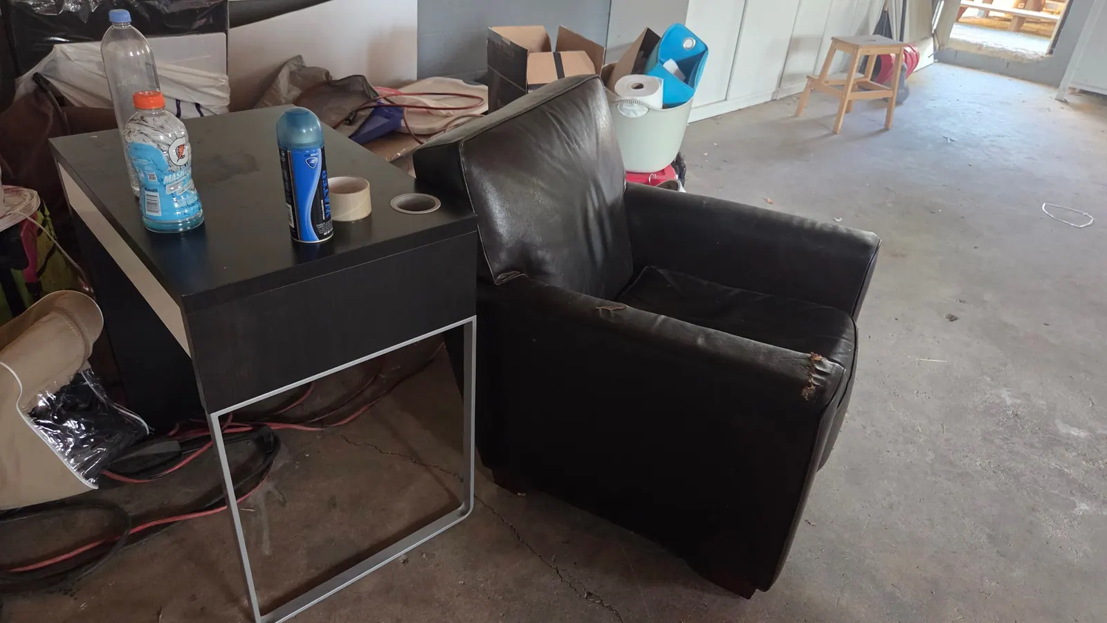 A desk a leather chair and boxes of household items to clear out