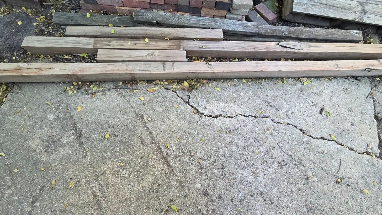 Old lumber and boards stacked on a patio before haul away