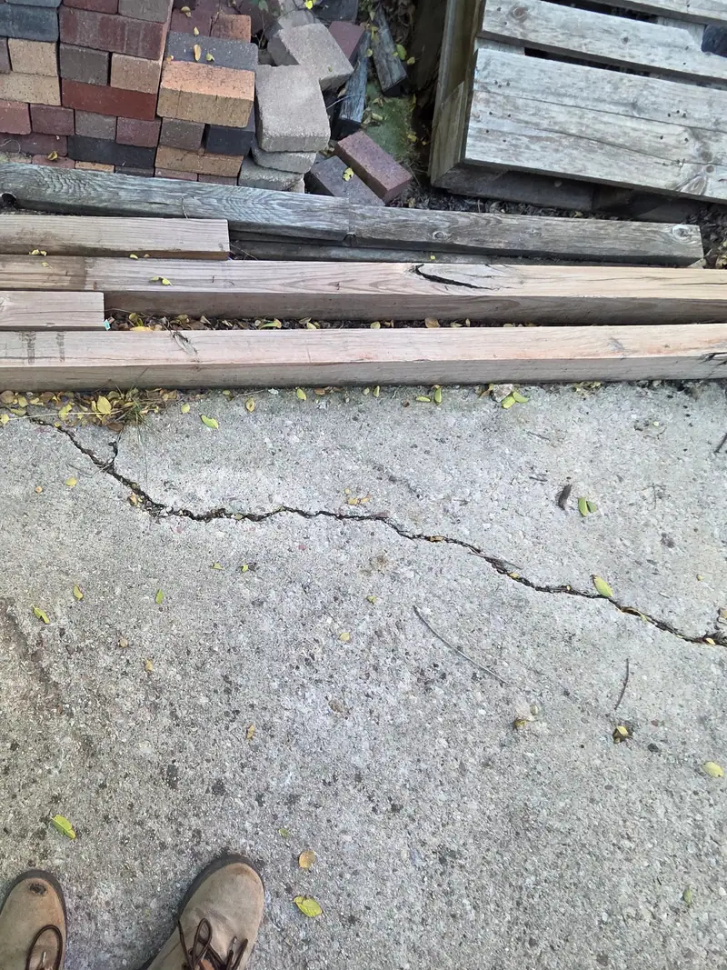 Old lumber and boards stacked on a patio before haul away