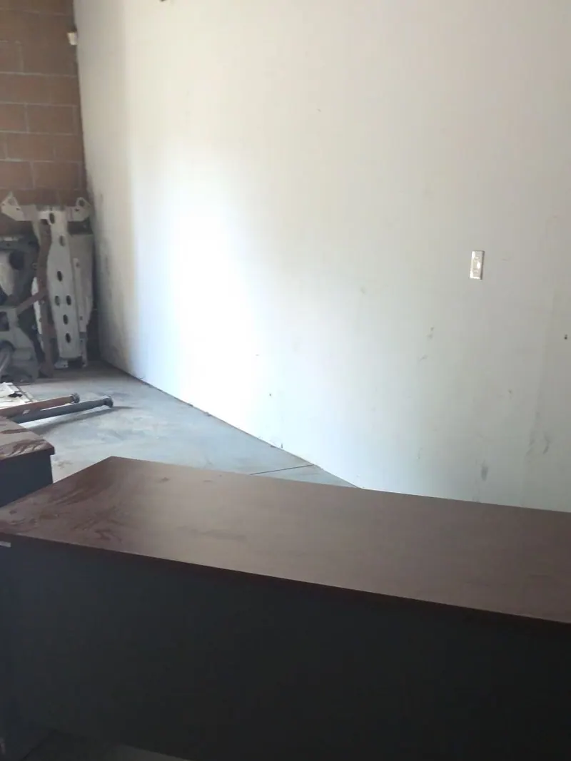 A heavy office desk and old equipment left in an empty commercial unit